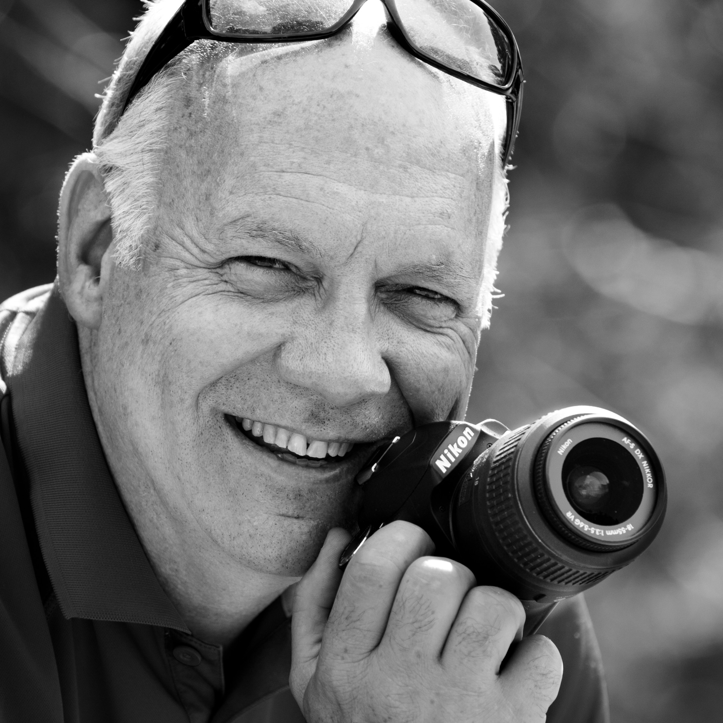Mister Andre Dussault, photo lover holding is camera in black and white. Testimonial for ADVENTURES room - travels & photo workshops.